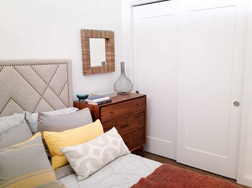 Bedroom with upholstered headboard and wooden dresser at 68 Beale Apartments, Quincy, 02169